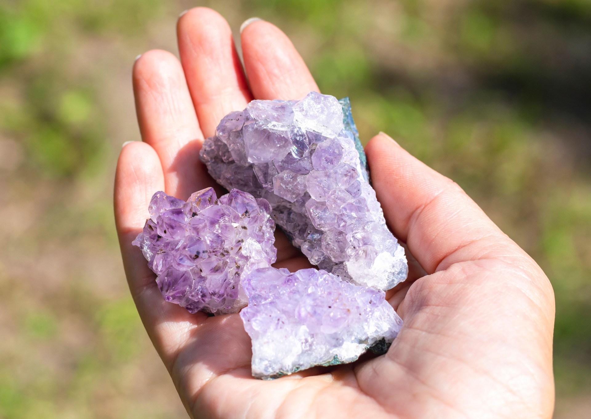 Natural mineral amethyst in hand. Semi-precious multi-colored stones, minerals close-up. Mineralogy. Collection of minerals.